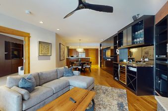 Living room in Settlers Lodge 104 with a sectional sofa, coffee table, and a large entertainment cabinet.