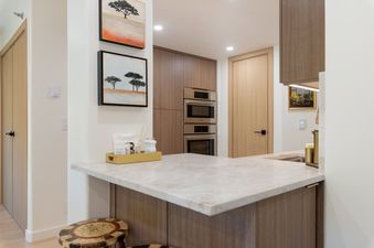 A modern kitchen in Signature Suite 552 featuring light-toned countertops, built-in wooden cabinetry, and stainless steel Bosch appliances.