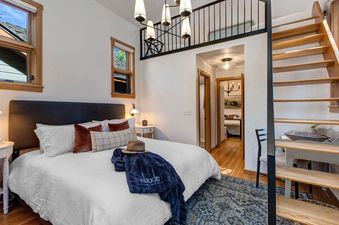 A cozy bedroom in Alpine Minnies Old Town features a comfortable bed and loft access.
