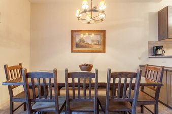 Rustic wooden dining table and chairs with warm lighting in Kutuk 203.