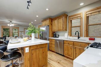 A beautifully appointed kitchen island features counter seating and elegant serveware at Abode Mountainside.