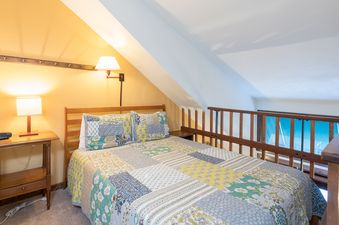 Cozy bedroom in Manitou Lodge 10 with a quilt-covered bed and warm lighting.