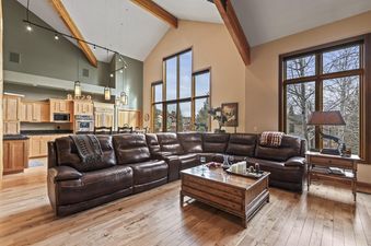 The Cove Retreat's living room offers a luxurious sectional and views of the outside.