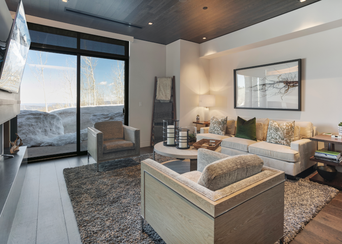 Living room with a large window overlooking a snow covered landscape.