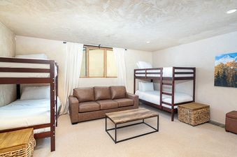 A cozy bedroom with two bunk beds, a couch, and a coffee table.