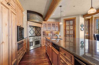 A kitchen with wooden cabinets, a large island, and stainless steel appliances.