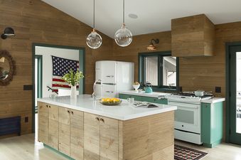 Modern rustic kitchen in Sundown Clear Creek featuring a wooden island, white countertops, and retro white appliances.