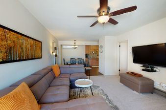 Living room with sectional sofa, coffee table, and flat screen TV.