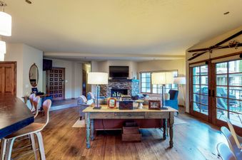 The living room of Westermere 310 features a fireplace, a large flat-screen television, comfy seating, and a rustic wood coffee table.