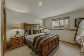 The Antlers Ridge Lodge features a beautifully appointed bedroom with rich wooden furniture.