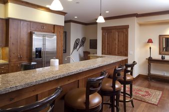 A well-appointed kitchen at Countryside 183 with a large granite bar and wooden barstools.