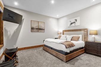 A cozy bedroom with a king-size bed, warm lighting, and tasteful artwork, offering a comfortable retreat at Timberline Lodge.