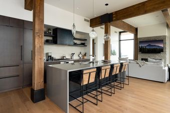 Moonlight Basin 201 Lakelodge features a modern kitchen with a large island, bar stools, and stainless steel appliances.