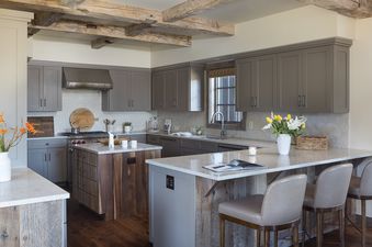 Modern rustic kitchen at Four Pines 77 with grey cabinets and a breakfast bar.