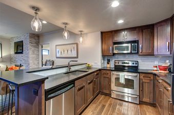The kitchen in Abode on Lower Main is fully equipped with stainless steel appliances and modern fixtures.