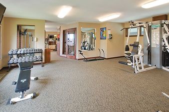 The fitness center at Ranch at Steamboat RA107 features a multi-station gym, a full set of dumbbells with a workout bench, and warm inviting decor.