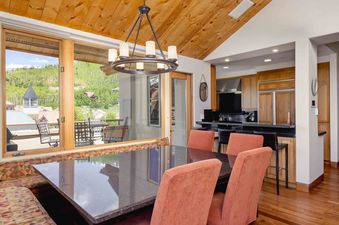 The dining area features a granite table and seating with views of the surrounding landscape at Plaza at Granita Penthouse.