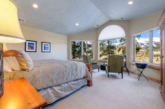 The bedroom at Aspenglow Chalet Above Downtown is spacious and bright with large windows overlooking the mountains.