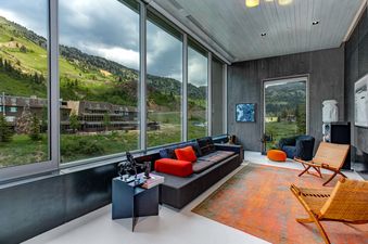 A modern lounge area at The Pinnacle at Powder Ridge with expansive windows offering panoramic mountain views.