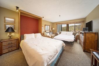 A cozy bedroom with a pull-out bed and a sofa bed, perfect for a relaxing stay at Snowblaze E310.