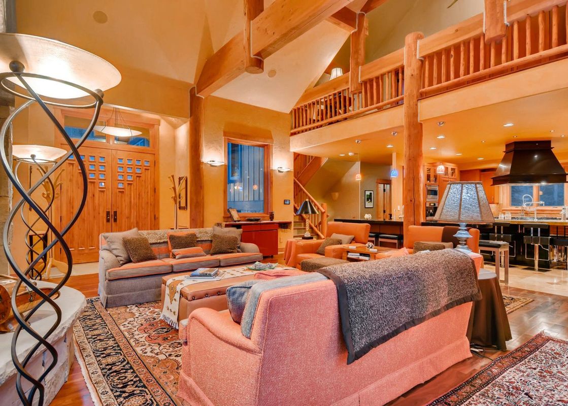 The Alders Chalet presents a large living room, dining area, and kitchen, all brightly lit with a warm and inviting atmosphere.