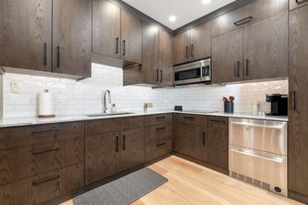 Signature Suite 518 features a modern kitchen with stainless steel appliances, white tile backsplash, and a spacious layout.
