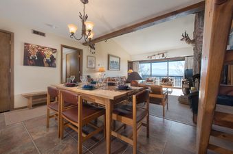 The cozy dining and living area at Whiteridge A4 with rustic decor and a mountain view.