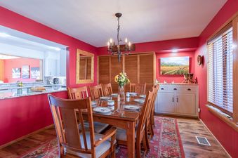 Dining table and chairs in the red-walled dining room of Windriver 12.