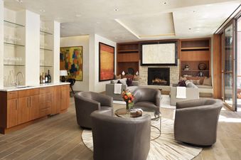 Living room interior with chairs, coffee table, and fireplace.