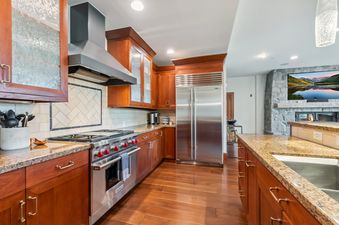 The Hummingbird Chateau features a spacious kitchen with rich wood cabinetry, stainless steel appliances, and gleaming granite countertops.