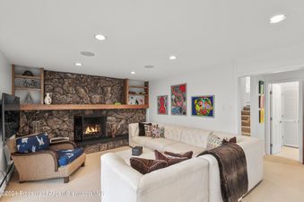 Living room with a stone fireplace and a large sectional sofa.