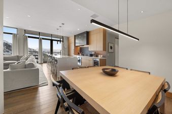 Open-plan dining, kitchen, and living room in One Snowmass East 603 with mountain views.