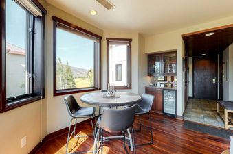 Meadows Clarion 2 dining area with table and chairs, a wet bar, and a hallway with a door leading to the outdoors.