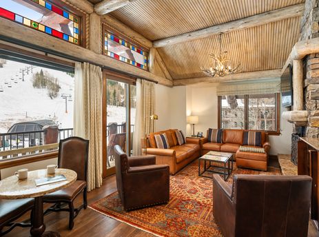 The Ritz Carlton Club 3 Bedroom Penthouse 4302 living area features comfortable leather sofas, stone fireplace, and mountain views.