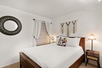 The serene bedroom of Snowcrest 205 features a comfortable bed, eclectic decor, and soft lighting for a relaxing stay.