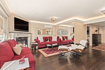 A luxurious and spacious living area in North of Nell Unit 2D featuring red sofas, a fireplace, a flat-screen TV, and contemporary decor.