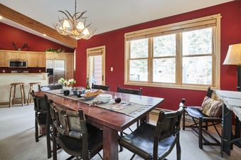 Cozy rustic dining area in Moose Creek 30 with red walls and a large window.