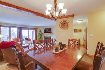 A cozy living room with a fireplace and a dining table with chairs.