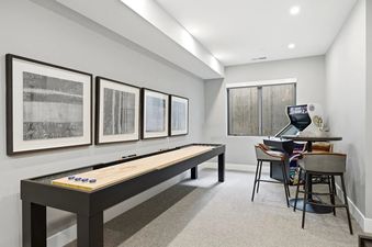 A modern games room with shuffleboard and arcade machine at The Ridge at Canyons Village.