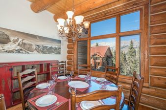 The dining area in Villas At Tristant 127 is set for a meal, with a beautiful view outside the window.