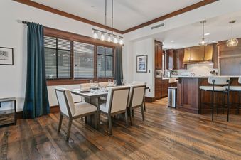 A modern dining table set for six next to a kitchen in Arrowleaf 209.