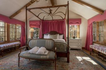 The master bedroom in Chalet 67 features a king-sized bed, a  plush seating area, large windows with beautiful views, and a luxurious feel.