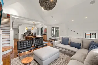 The image showcases the luxurious and modern interior of Creekside Haven, featuring an open-concept living area with a comfortable sofa, dining space, and a well-appointed kitchen.
