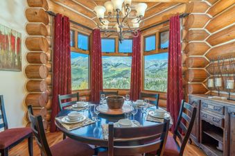 The dining area in Townhomes On The Creek 119 features a round table set for a meal and a picturesque mountain view.