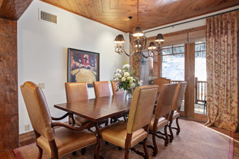 Grand Lodge Three Bedroom Deluxe 404 dining room with wood table, chairs and a chandelier over the table.