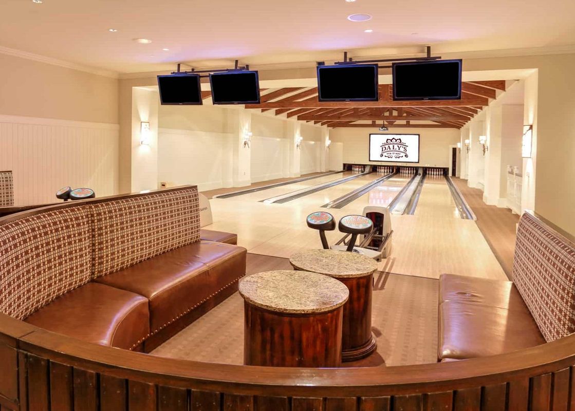 A luxury bowling alley at Montage Two Bedroom Flagstaff Suites, featuring multiple lanes, comfortable seating areas, and flat-screen TVs.
