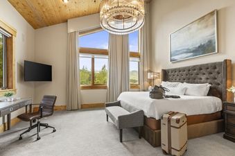 A bedroom in Oak Haven is bright and spacious with a king bed, desk, and television.