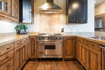 The kitchen at Silver Star 1305 showcases warm wood cabinetry, granite countertops, and stainless steel appliances including a Viking range.