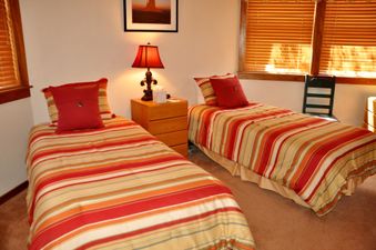Two twin beds with striped bedding in a bedroom.