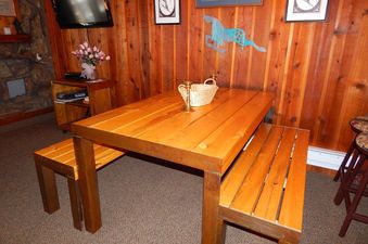 The dining area features a large wooden table with benches, suitable for gathering and meals.